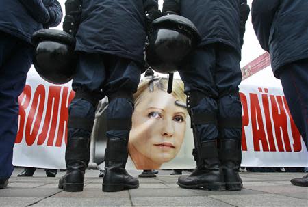 A banner with the portrait of jailed former prime minister Yulia Tymoshenko is seen as police stand guard during an opposition rally in front of the Parliament building in Kiev November 13, 2013. REUTERS/Gleb Garanich