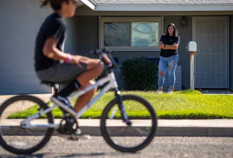 Danielle Lara watches her 11-year-old son ride his bike in front of her home in Blythe on Wednesday, Oct. 12, 2022.