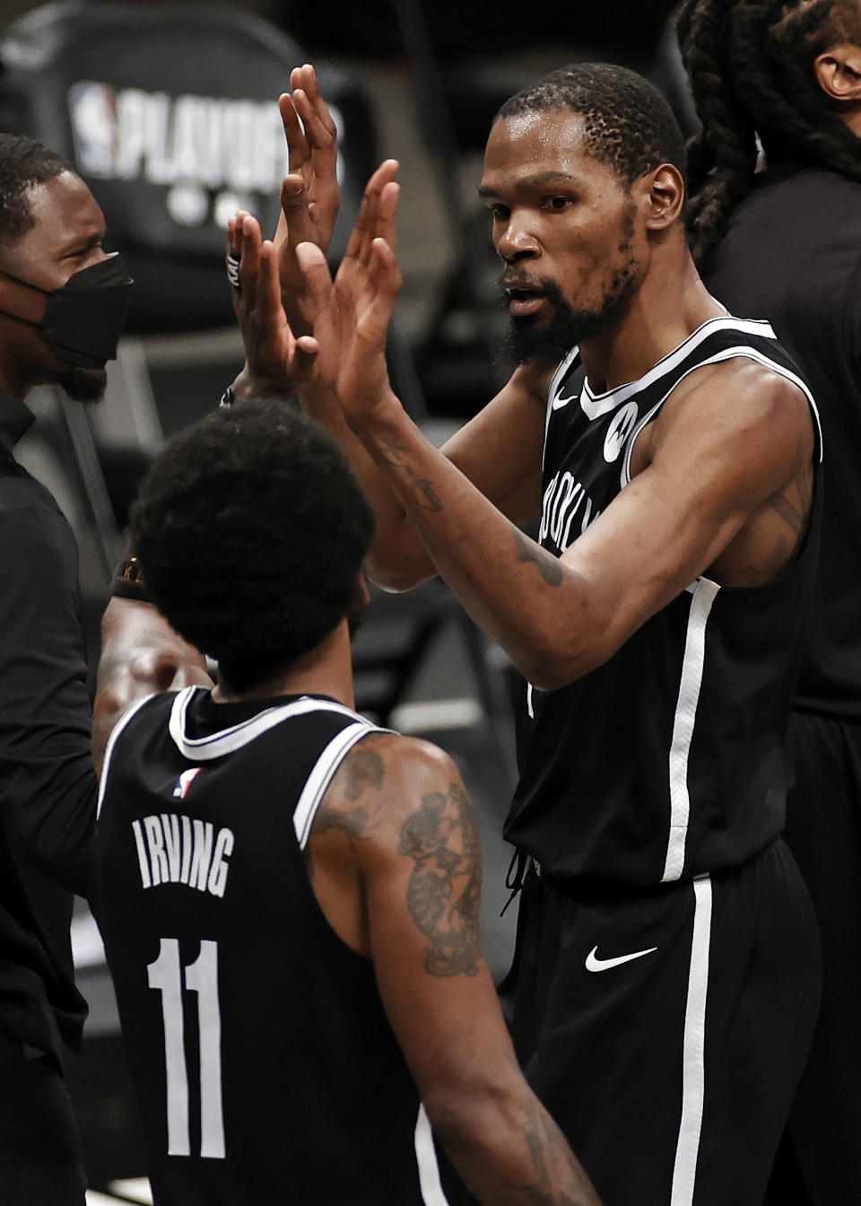 Brooklyn Nets forward Kevin Durant high-fives Kyrie Irving (11) during the second half of Game 1 of the team's NBA basketball second-round playoff series against the Milwaukee Bucks on Saturday, June 5, 2021, in New York. The Nets won 115-107. (AP Photo/Adam Hunger)