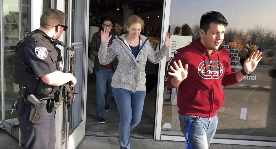 Shoppers with their hands raised are evacuated from Fashion Place Mall in Murray, Utah, after a shooting on Sunday, Jan. 13, 2019. (AP Photo/Rick Bowmer)