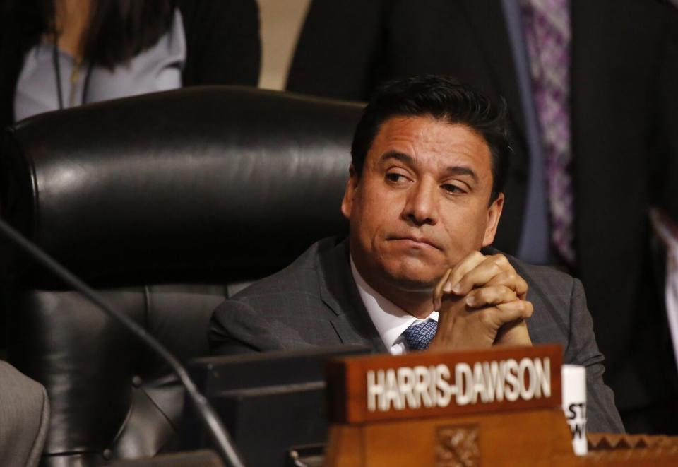 Jose Huizar seated with hands clasped at a City Council meeting.