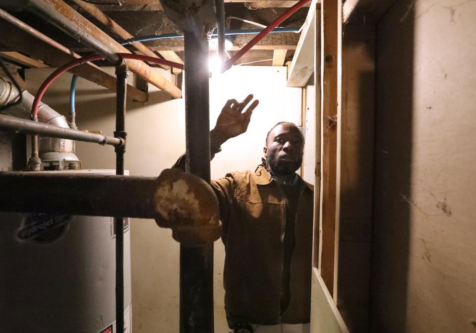 Rockland County Building Inspector, Jack Lavalasse, inspects a house next to the two-family house that burned in Spring Valley.