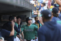 Seattle Mariners' Cal Raleigh, center, celebrates in the dugout after hitting solo home run during the second inning of a baseball game against the Oakland Athletics, Saturday, May 11, 2024, in Seattle. (AP Photo/Jason Redmond)