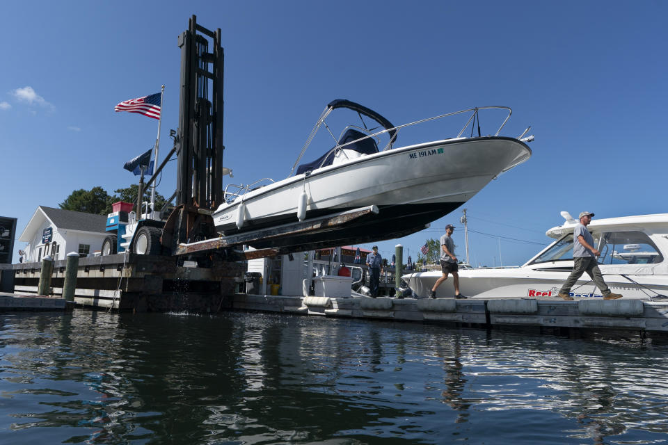 A boat is lifted from the water in advance of Hurricane Lee at York Harbor Marine, Thursday, Sept. 14, 2023, in York, Maine. Many boat owners have opted to put their vessels in storage earlier than usual to avoid risking damage from this weekend's storm. (AP Photo/Robert F. Bukaty)