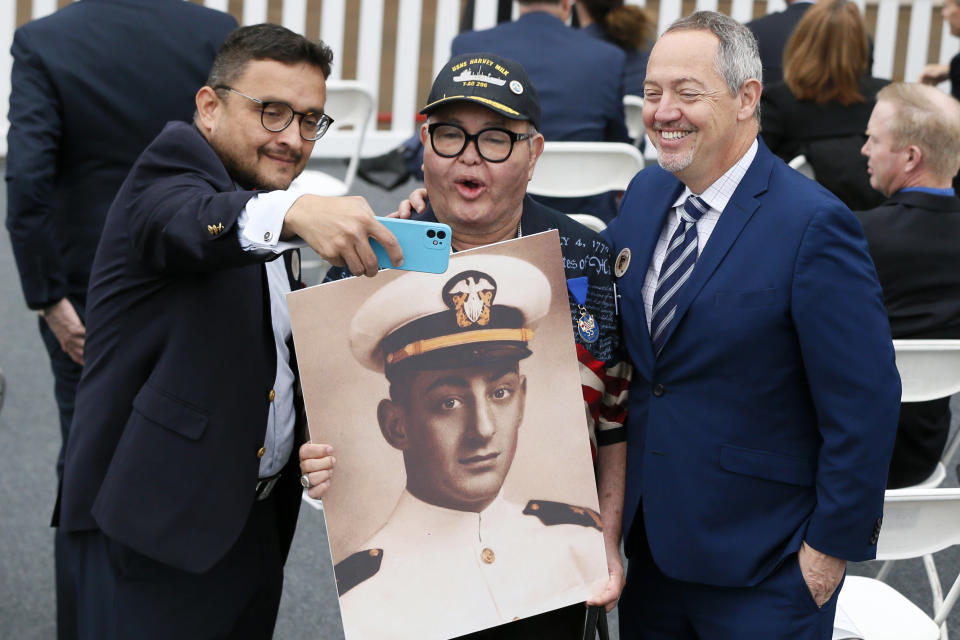 David Campos, left, vice chair of the California Democratic Party, takes a selfie with Nicole Murray-Ramirez, center, an LGBT activist, holding a photo of Harvey Milk, and Bevan Dufty, right, director of the San Francisco Bay area rapid transit district, prior to the launching of the USNS Harvey Milk, a fleet replenishment oiler ship named after the first openly gay elected official, Saturday, Nov. 6, 2021 in San Diego. The Navy ship is the second of six vessels in the Navy's John Lewis-class program, second to the USNS John Lewis. (AP Photo/Alex Gallardo)