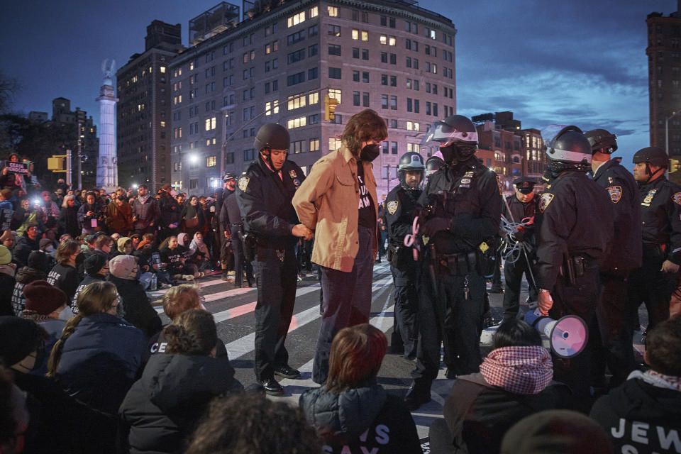 Police arrest protesters as they block traffic during a pro-Palestinian demonstration demanding a permanent cease-fire in Gaza, near the home of Sen. Chuck Schumer in the Brooklyn borough of New York, Tuesday, April 23, 2024. (AP Photo/Andres Kudacki)