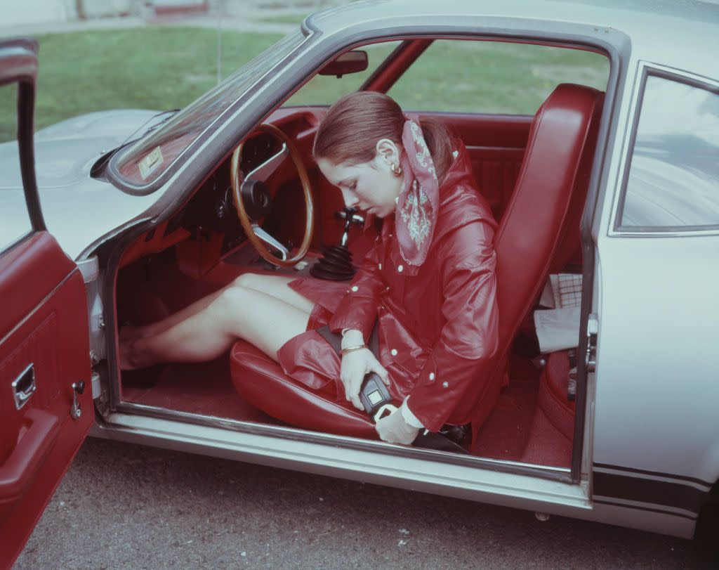 Young woman fastening seat belt