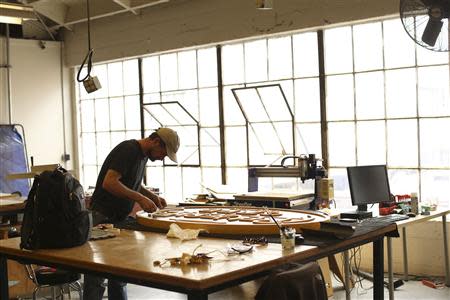 A designer works on a restaurant sign at TechShop in the South of Market neighborhood in San Francisco, California April 24, 2014. REUTERS/Robert Galbraith