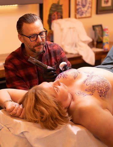 <p>Bryndi Schult</p> Tattoo artist Chris Yaws working on Kerry Wright