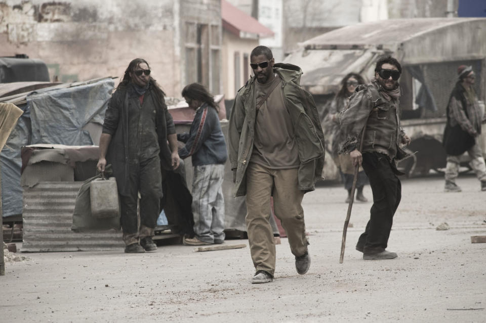 Denzel Washington makes his way down a dirty, post-apocalyptic city road in “The Book of Eli”