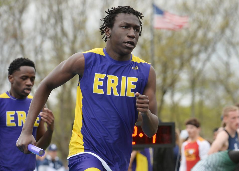 Erie High School's Peter Kani takes the baton from teammate Bonheur Kitongo, back left, during Joe Sanford's McDowell Track and Field Invitational on Friday.