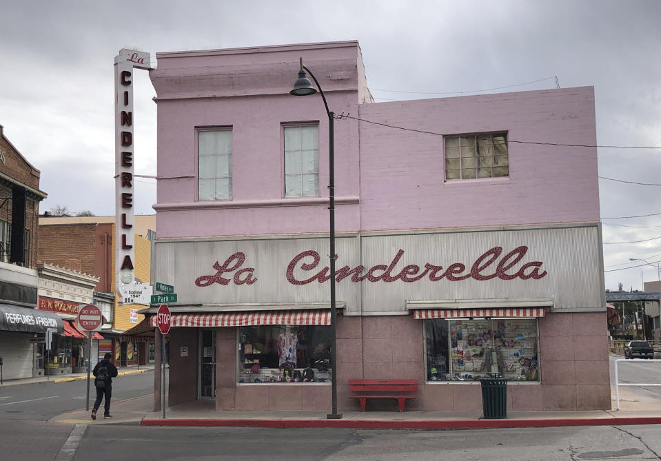 A man walks past a shuttered clothing store in the border town of Nogales, Arizona on March 15, 2021. The store has been in business for nearly half a century but closed because of the pandemic for almost a year, with its main customer base, Mexican day-trippers, largely unable to come to the U.S. and shop. (AP Photo/Suman Naishadham)