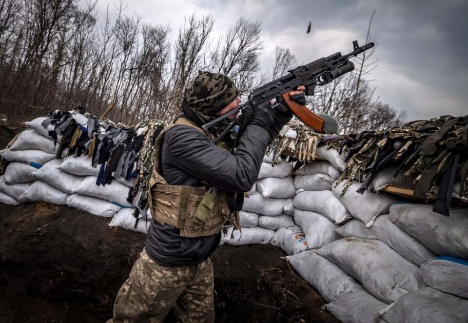 Ein ukrainischer Soldat schießt mit einem Sturmgewehr aus einem Graben an der Frontlinie östlich von Charkiw auf eine russische Drohne. - Copyright: Fadel Senna/ AFP/ Getty