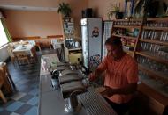 A bartender drafts a glass of beer inside the U Kantu pub in the village of Myslovice