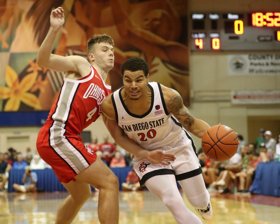 Ohio State guard Sean McNeil (4) guards against San Diego State guard Matt Bradley (20) during the first half of an NCAA college basketball game, Monday, Nov. 21, 2022, in Lahaina, Hawaii. (AP Photo/Marco Garcia)