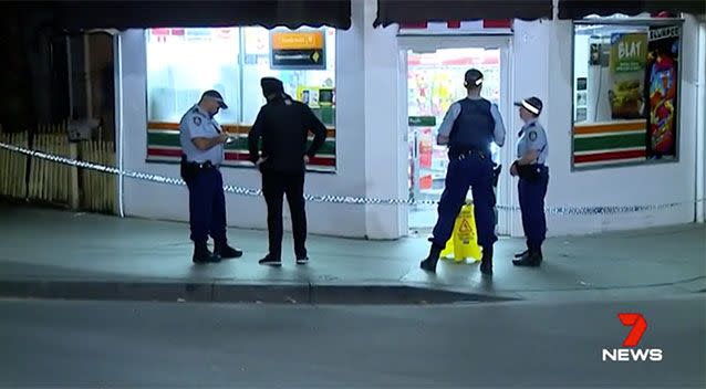 Police question a 7-Eleven worker who was threatened by the armed gang. Source: 7 News