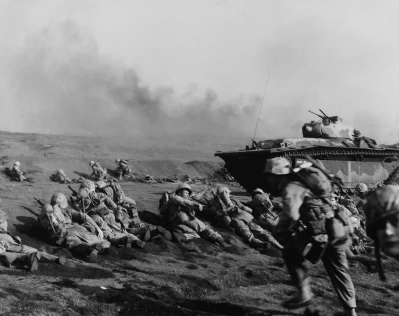 U.S. Marines of the Second Battalion, Seventh Regiment, wait to move inland on Iwo Jima