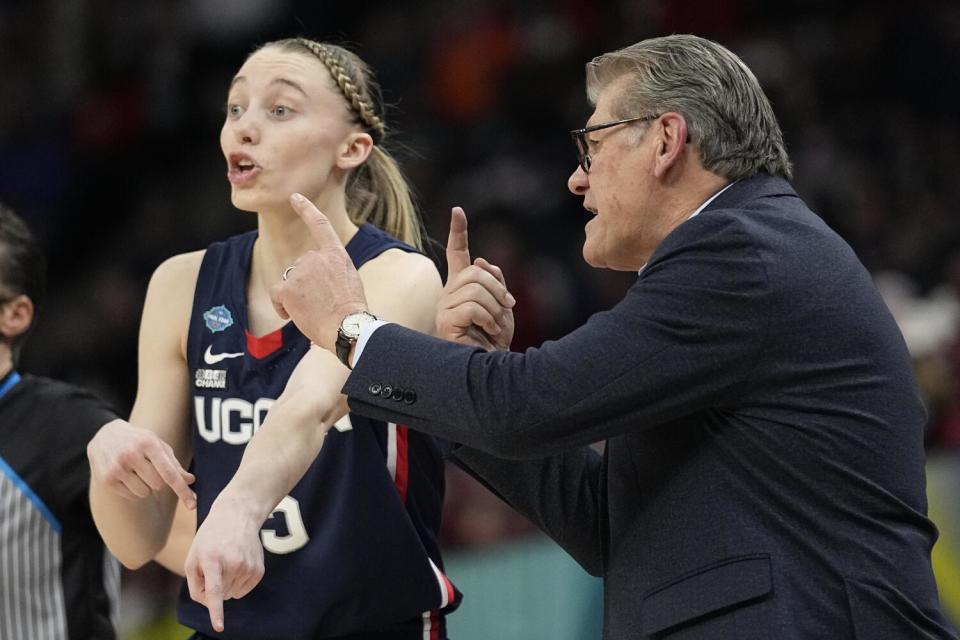 Connecticut coach Geno Auriemma, right, and guard Paige Bueckers talk strategy.