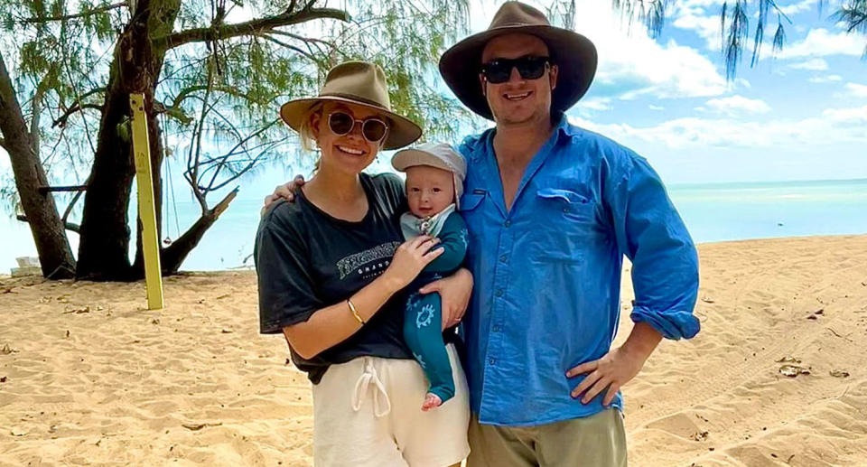 Queensland couple Hannah Jeffries and her fiance Dylan Stitt on beach with baby. 