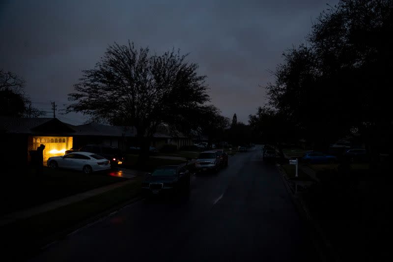 A car idles in a driveway on Jordan Drive, a street with no power in the early morning in Corpus Christi