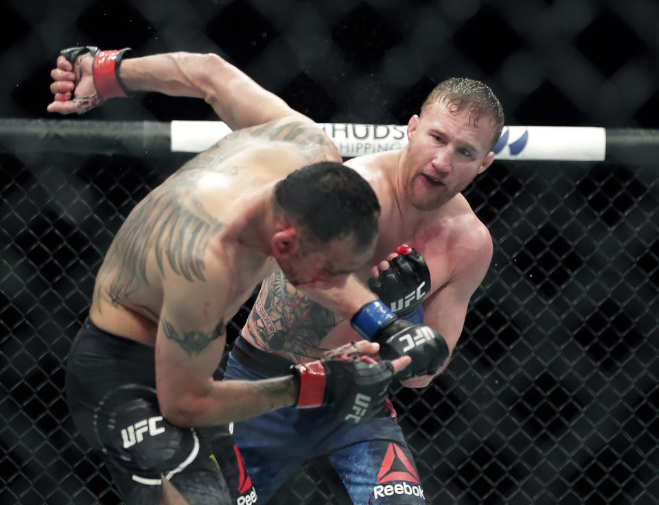 FILE - In this May 10, 2020, file photo, Tony Ferguson, left, falls backward after taking a punch from Justin Gaethje during a UFC 249 mixed martial arts boutin Jacksonville, Fla. Khabib Nurmagomedov will risk his unbeaten record and his UFC lightweight title against interim champion Gaethje in the main event of UFC 254 in Abu Dhabi on Saturday, Oct. 24, 2020. (AP Photo/John Raoux, File)