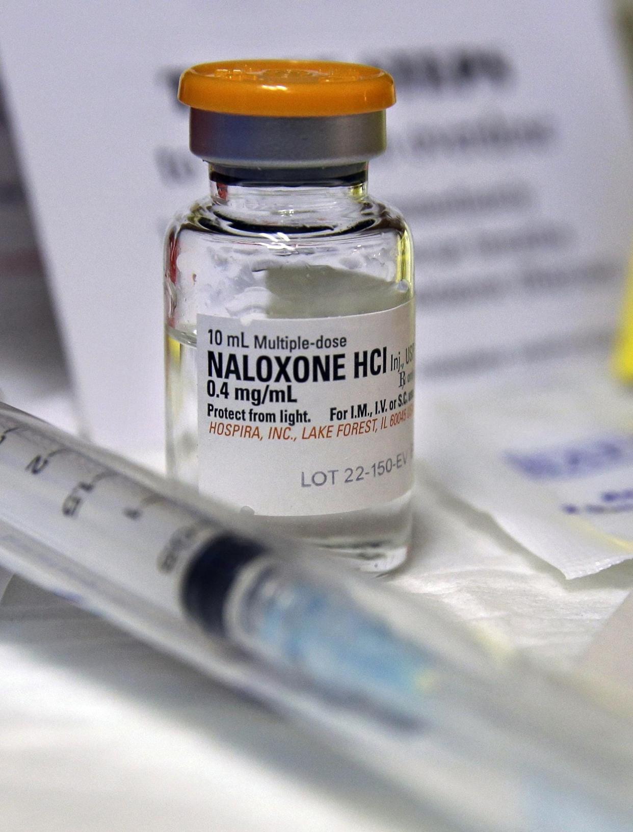 A small bottle of the opiate overdose treatment drug, naloxone, also known by its brand name Narcan, is displayed.