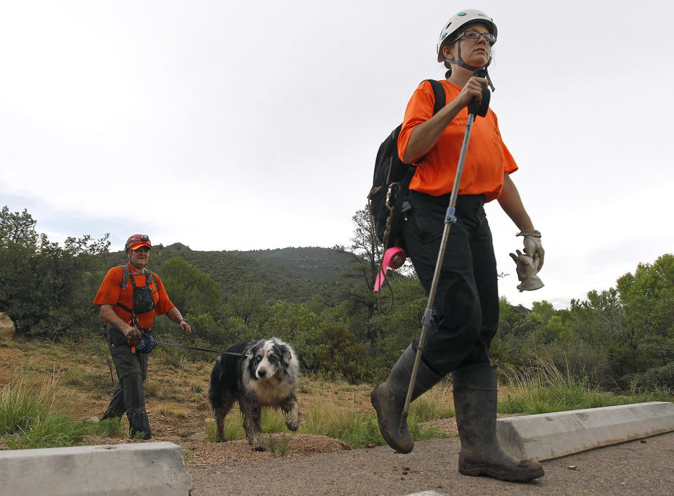 <p>Members of the Tonto Rim Search and Rescue team exit a section of forest after searching along the banks of the East Verde River for victims of a flash flood, Sunday, July 16, 2017, in Payson, Ariz. (AP Photo/Ralph Freso) </p>
