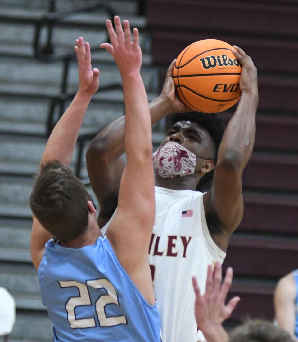 Ashley's Mikhail Pocknett shoots over Hoggard's Mason Bagley at Ashley in Wilmington, N.C., Tuesday, February 2, 2021. MATT BORN/STARNEWS