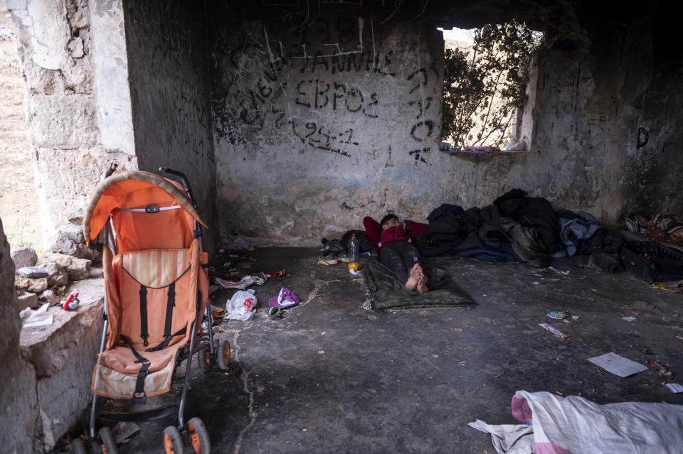 A Syrian man rests on the floor of an abandoned army outpost near Ieropigi village, northern Greece, at the Greek - Albanian border, on Tuesday, Sept. 28, 2021. A relatively smooth section of Greece's rugged border with Albania is turning into a major thoroughfare north for migrants in Greece seeking a better life in Europe's prosperous heartland. (AP Photo/Giannis Papanikos)