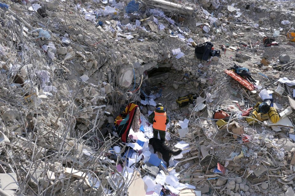 A man walks with his dog among the debris of a collapsed building in Antakya, southern Turkey, Tuesday, Feb. 14, 2023. Turkish President Recep Tayyip Erdogan announced Tuesday that more than 35,000 people have died in Turkey as a result of last week's earthquake, making it the deadliest such disaster since the country's founding 100 years ago. While the death toll is almost certain to rise even further, many of the tens of thousands of survivors left homeless were still struggling to meet basic needs, like finding shelter from the bitter cold. (AP Photo)