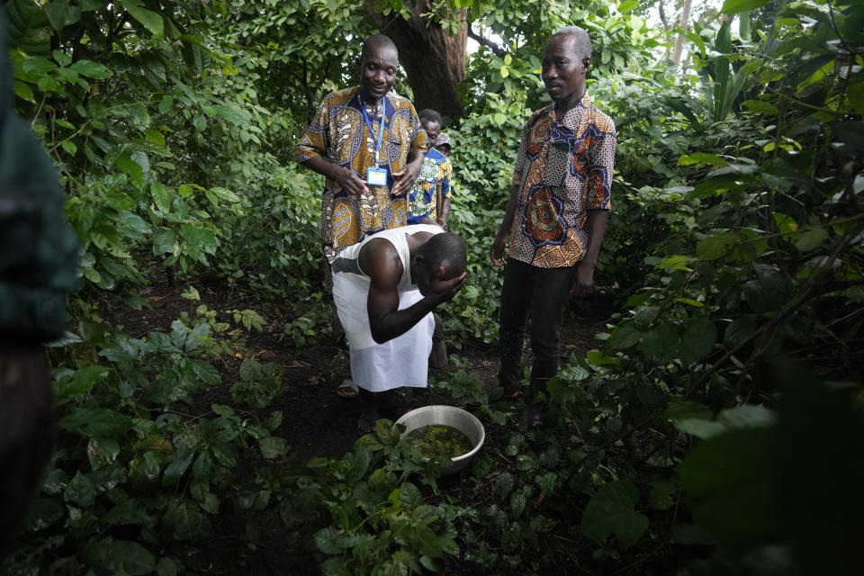 A voodoo worshiper washes his face after visiting the Bohouezoun sacred forest in Benin, on Thursday, Oct. 5, 2023. As the government grapples with preserving the forests while developing the country, Voodoo worshippers worry the loss of its spaces could have far reaching effects. (AP Photo/Sunday Alamba)