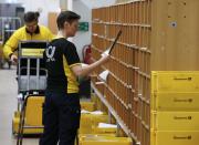 A postwoman of the German postal and logistics group Deutsche Post sorts mail at a sorting office in Berlin's Mitte district, December 4, 2013. Deutsche Post, the world's number one postal and logistics group, transported around 18 billion letters in 2012. REUTERS/Fabrizio Bensch (GERMANY - Tags: BUSINESS EMPLOYMENT)