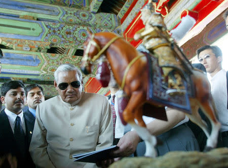 FILE PHOTO: Indian Prime Minister Atal Bihari Vajpayee (C) looks at a gift named "Portrait of the Qing Emperor Qianlong Reviewing" given to him by the Forbidden City in Beijing, China June 24, 2003. REUTERS/Guang Niu/File Photo