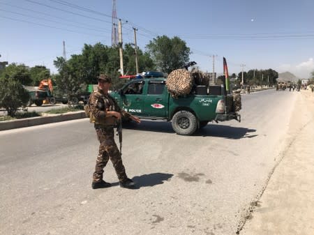 An Afghan security force member keeps watch at the site of a suicide bomb blast in Kabul