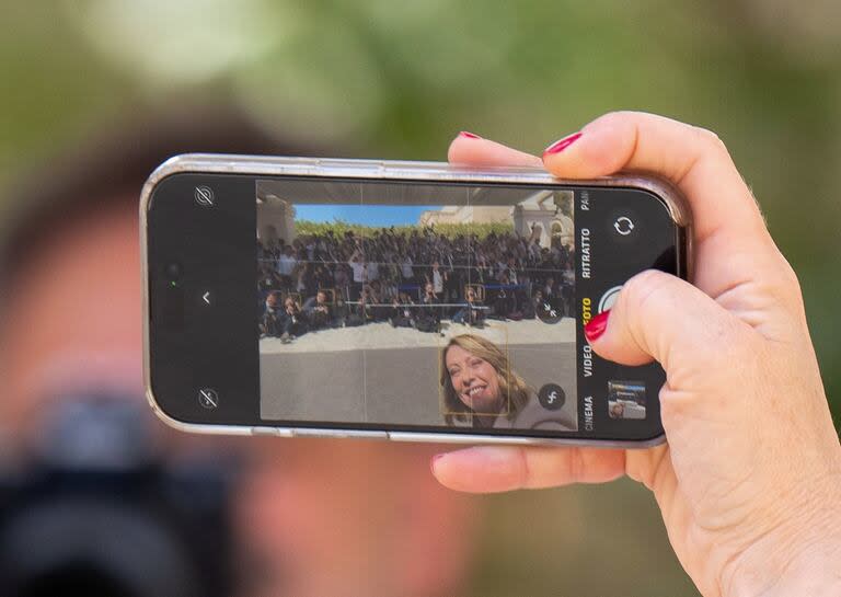 Giorgia Meloni saca un selfie con los fotógrafos en la cumbre del G7