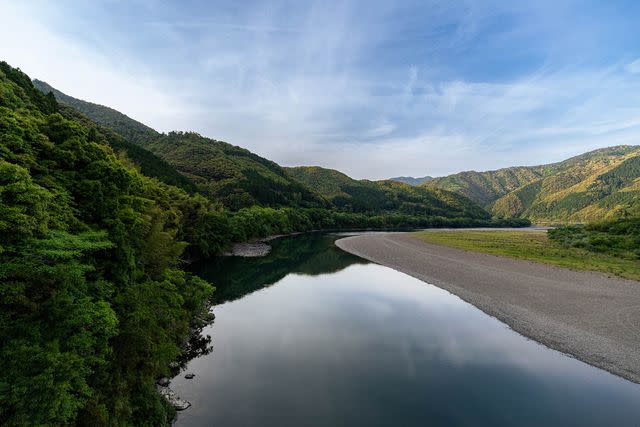 <p>Anubhav C/Getty Images</p> The Shimanto River flowing through mountains in the western Kochi Prefecturein of Shikoku, Japan