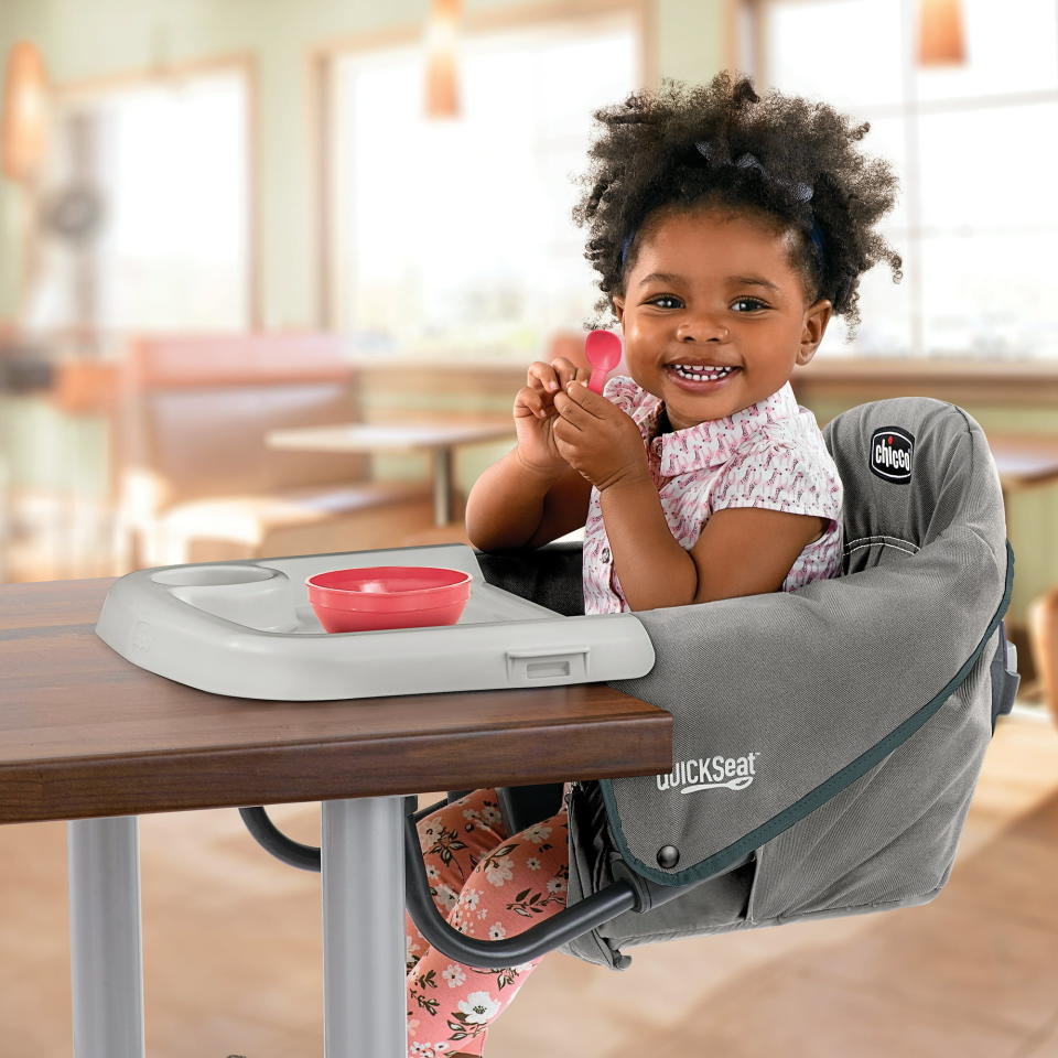 A baby in the chair attached to a table