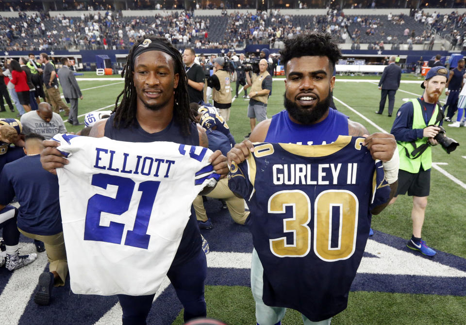 FILE - In this Oct. 1, 2017, file photo, Los Angeles Rams' Todd Gurley, left, and Dallas Cowboys' Ezekiel Elliott, right, swap jerseys after an NFL football game, in Arlington, Texas. Gurley is a big football fan, and Elliott is one of his favorite players. The good feelings are mutual heading into the Cowboys' playoff visit to the Rams and a showdown between the NFL's two premiere running backs. (AP Photo/Michael Ainsworth, File)