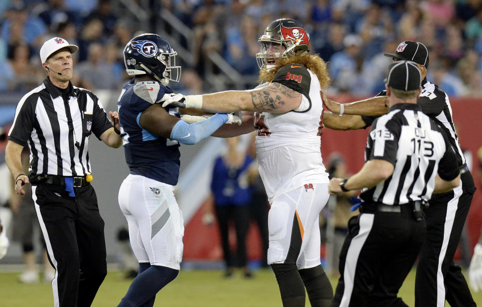 Officials break up Tennessee Titans linebacker Jayon Brown, left, and Tampa Bay Buccaneers offensive guard Ryan Jensen, right, in the first half of a preseason NFL football game Saturday, Aug. 18, 2018, in Nashville, Tenn. (AP Photo/Mark Zaleski))
