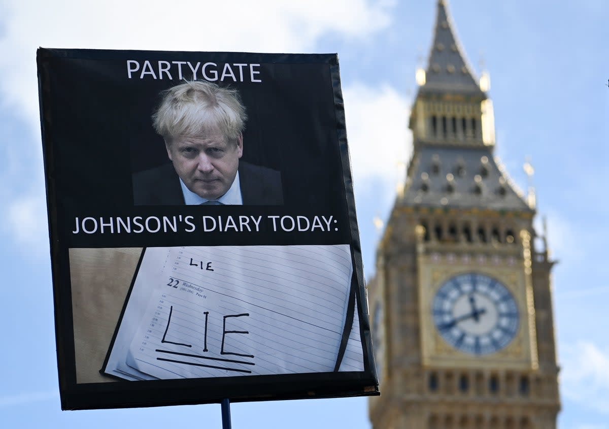 A protester demonstrates against former prime minister Boris Johnson outside parliament in London this week (EPA)