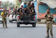 Afghan security forces transport detained prisoners who escaped from a jail after insurgents attacked a jail compound in Jalalabad