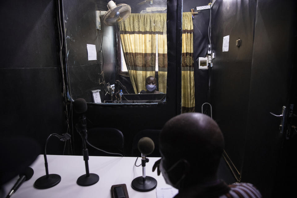 Mariama Sawadogo, 44, works as a radio host at Zama Radio, in Kaya, Burkina Faso, Monday, Oct. 25, 2021. Many guests and listeners in Burkina Faso call her "aunty" as she gently guides them to the right answers and awards prizes such as soap and washing buckets. In the West African country of Burkina Faso, many feel the government has let them down during the pandemic. Tests, vaccines and messaging often miss many residents, despite a $200 million budget for virus-response efforts. In a region where women are responsible for family work and community relationships, they’ve stepped up to fill in gaps. (AP Photo/Sophie Garcia)