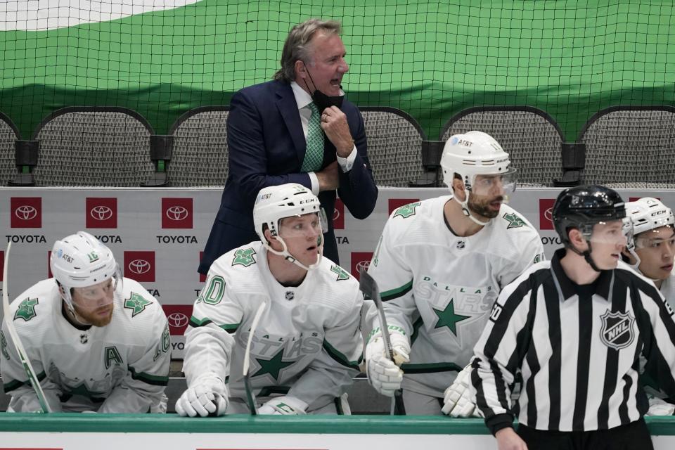 Dallas Stars head coach Rick Bowness, rear, gives instructions from the bench in the first period of an NHL hockey game against the Detroit Red Wings in Dallas, Tuesday, April 20, 2021. The Stars' Joe Pavelski, bottom left, Ty Dellandrea (10), Andrew Cogliano (11), linesman Libor Suchanek and Jason Robertson (21) look on at play. (AP Photo/Tony Gutierrez)