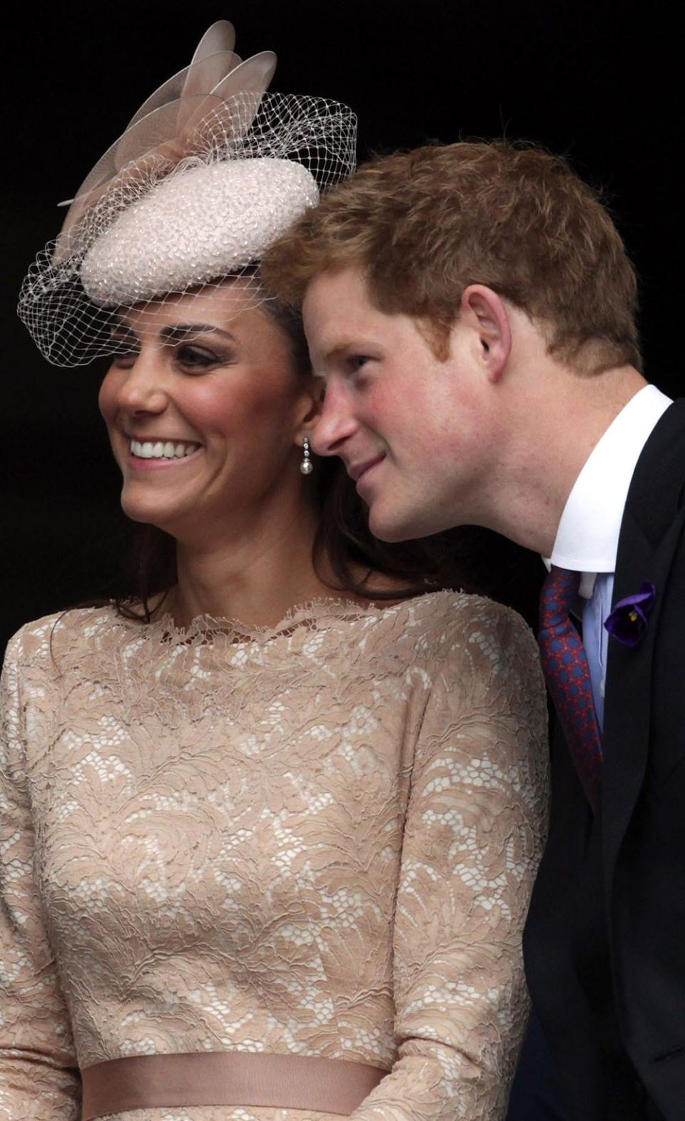 Prince Harry leaning next to Kate Middleton who is smiling