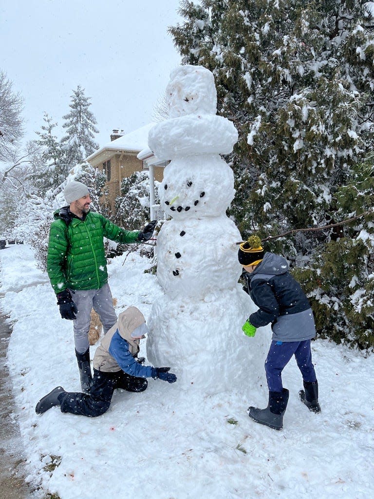 Max and Fitz Hassell work on a 10-foot snowman with their dad, Tim, on Saturday afternoon near N. 73rd St. and Hillcrest in Wauwatosa.