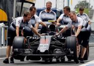 Formula One - F1 - Malaysia Grand Prix - Sepang, Malaysia- 29/9/16. Crew members push the car of McLaren's Jenson Button of Britain in the pit. REUTERS/Edgar Su