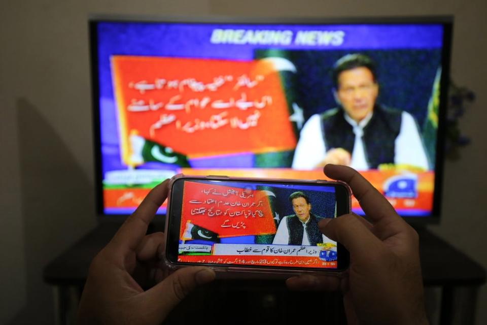 People watch a televised speech by the Pakistan Prime Minister Imran Khan, a day after the country's top court set aside the government's move to block a no-trust vote (EPA)