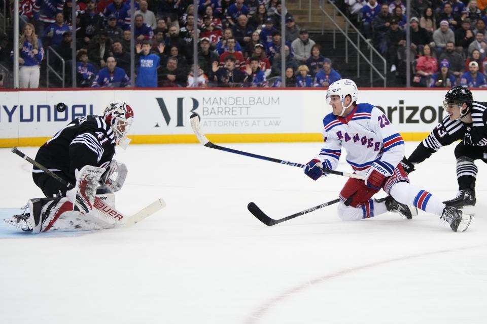 New Jersey Devils goaltender Vitek Vanecek (41) stops a shot on goal by New York Rangers' Adam Fox (23) during the first period of an NHL hockey game Thursday, March 30, 2023, in Newark, N.J. (AP Photo/Frank Franklin II)