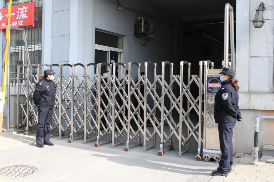 Security officers stand guard at an entrance to a court building in Dandong in northeastern China's Liaoning Province, Friday, March 19, 2021. China was expected to open the first trial Friday for Michael Spavor, one of two Canadians who have been held for more than two years in apparent retaliation for Canada's arrest of a senior Chinese telecom executive. (AP Photo/Ken Moritsugu)