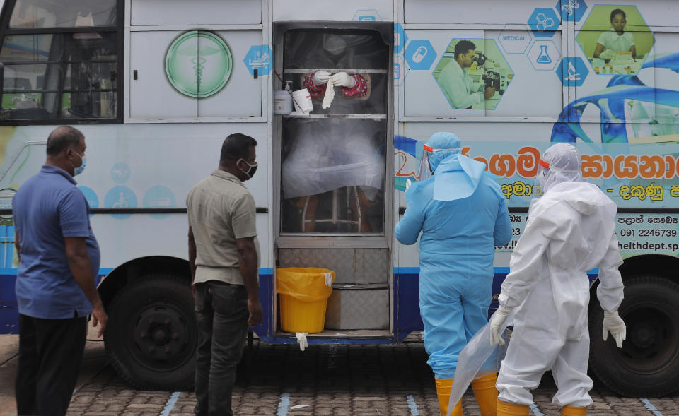 Sri Lankans wait to give swab samples to test for COVID-19 in Minuwangoda, Sri Lanka, Tuesday, Oct. 6, 2020. (AP Photo/Eranga Jayawardena)